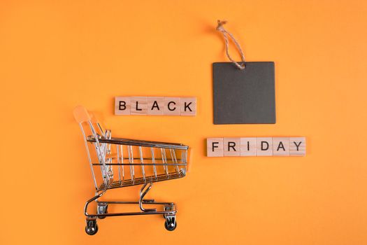 Sale and Black Friday concept. Mini shopping cart on a yellow background.