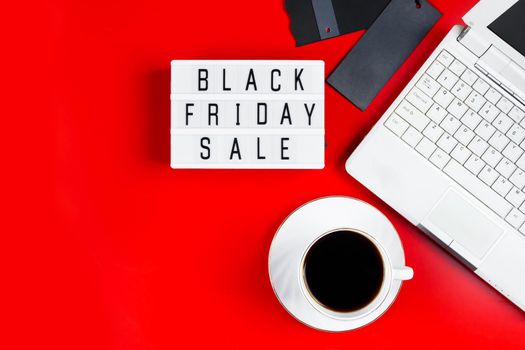 Black Friday sale concept. Laptop and coffee cup on a red background. Banner for advertising.