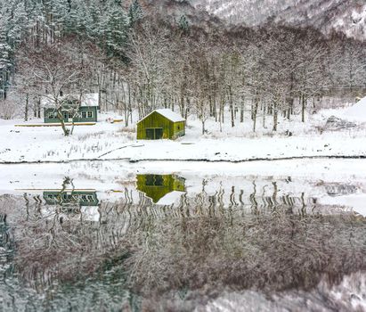 wooden houses on the banks of the Norwegian fjord with reflection in water