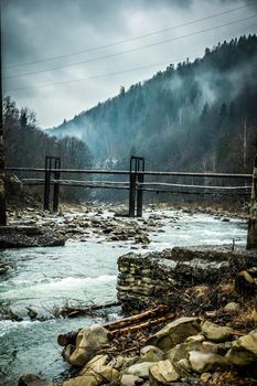 beautiful mountain landscape with lake and bridges in fog in Ukrainian Carpathians