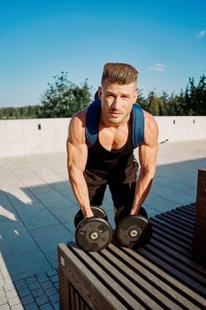 athletic man pumped up body in the park workout fitness fresh air. High quality photo