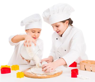 little boy and girl in white uniform kneating dough together