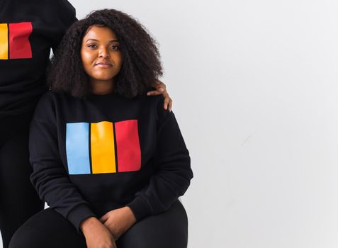 Happy African American woman and man have relationships, toothy smile, happy to meet with friends, dressed casually on white background. Emotions and friendship