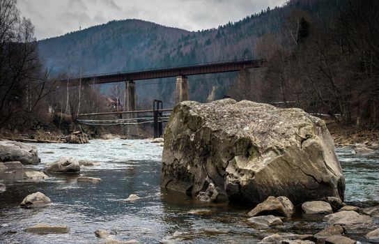 landscape in Carpathian mountains with river, railway bridge