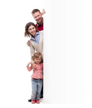 father, mother and little daughter peek out from behind empty blank isolated on white background