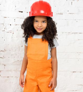cute little girl in orange repairmen uniform and helmet