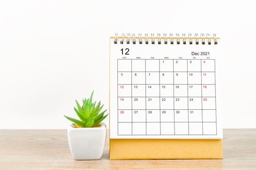 The December 2021 desk calendar on wooden table.