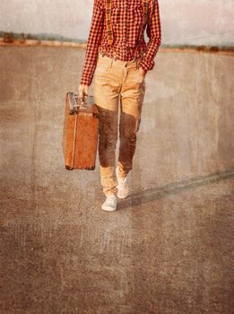 Image of traveler legs goings, vintage suitcase, travel theme. Face is not visible. Vintage image