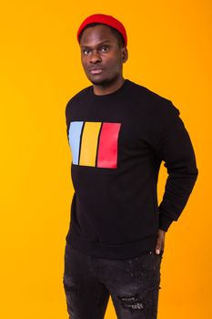 Studio shot of young handsome African man wearing hoodie against white background.