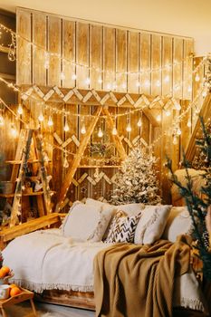 Home Christmas interior, with a Christmas tree and lots of glowing garlands and light bulbs. Preparing for the Christmas party at home.