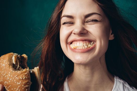 woman eating hamburger fast food snack close-up. High quality photo