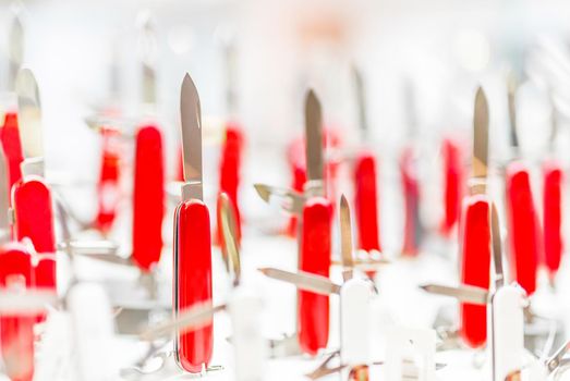 many red folding knives on a store counter