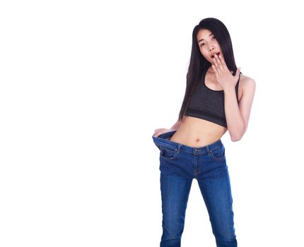 Shocked slim fitness woman in old jeans after losing weight isolated on a white background