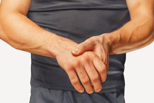Pain in a male wrist. Man holds his hand.