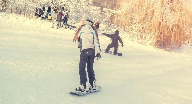 girl on snowboard on snowhill