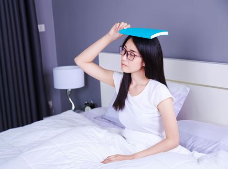 woman with a book on bed in the bedroom at home