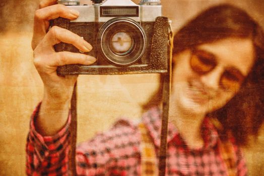 Smiling young woman with retro photo camera, focus on camera. Vintage image