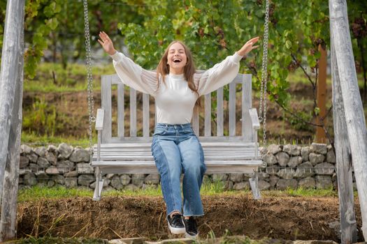 teen girl having fun on playground. childhood happiness. relax in park. summertime activity. positive emotions. free happy child on swing. kid swinging outdoor.