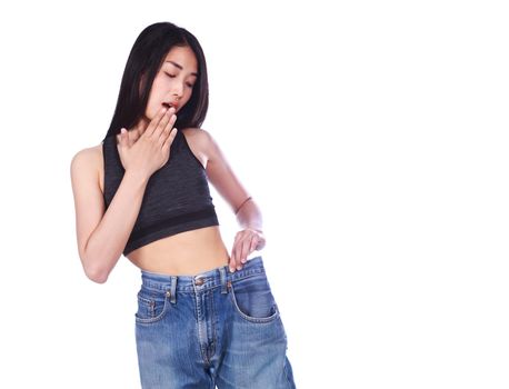 Shocked slim fitness woman in old jeans after losing weight isolated on a white background