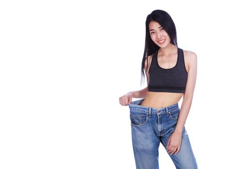 woman shows her weight loss and wearing her old jeans isolated on a white background