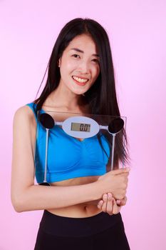 happy slim woman holding a weight scale