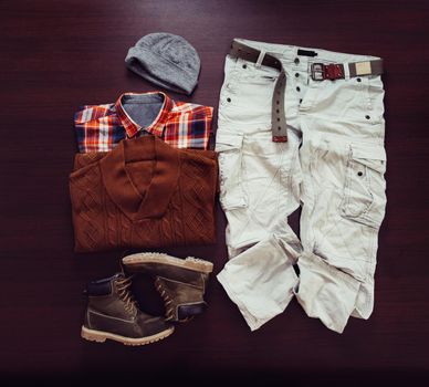 Set of male clothing in hipster style on wooden background, top view