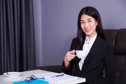 happy young business woman working and drinking a cup of coffee