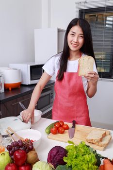 woman preparing bread to sandwich toaster in kitchen room at home