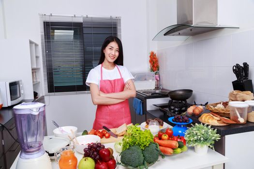 woman standing with arms crossed in kitchen room at home