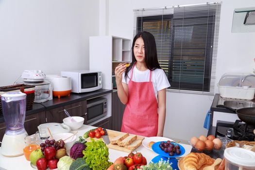 woman eating a chocolate donut in kitchen room at home