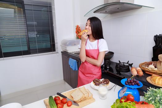 woman eating a bread in kichen room at home