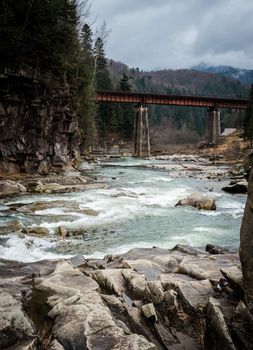 landscape in Carpathian mountains with river, railway bridge