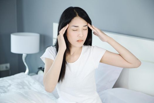 woman headache on bed in the bedroom