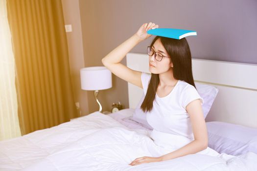 woman with a book on bed in the bedroom at home