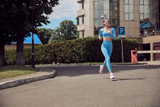 Beautiful fit young woman jogger is running outdoors