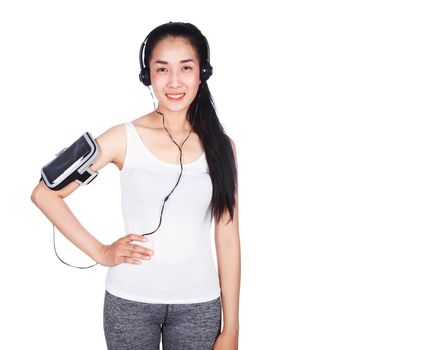 young smiling fitness woman listening to music with earphones isolated on a white background