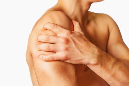 Unrecognizable man compresses his shoulder, pain in the shoulder, side view. Shoulder closeup