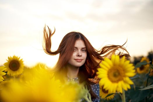 pretty woman with hat in the field of sunflowers freedom nature. High quality photo