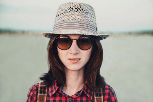 Portrait of smiling young woman in sunglasses and hat outdoor