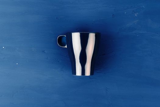 Porcelain coffee cup on classic blue background, top view. Close up.