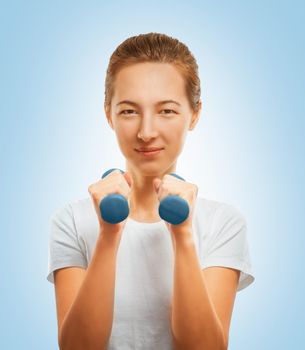 Young woman makes exercise with a dumbbell on a blue background