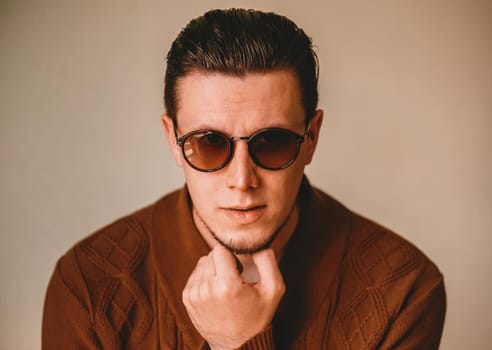 Portrait of handsome brunet man in sunglasses indoor