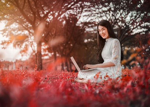 beautiful woman using laptop in the outdoor park