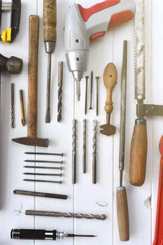 different carpenters and mechanics tools on a white wooden table