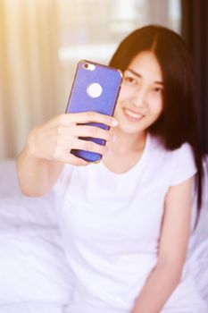 woman taking selfie on bed in the bedroom