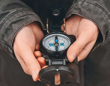 Hiker woman holding a compass on nature. Close-up image