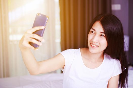 woman taking selfie on bed in the bedroom