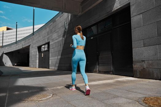 Beautiful fit young woman jogger is running outdoors