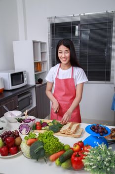 woman using knife to cutting broccoli in kitchen room at home