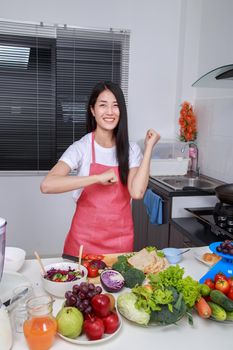 happy beautiful woman cooking in kitchen room at home